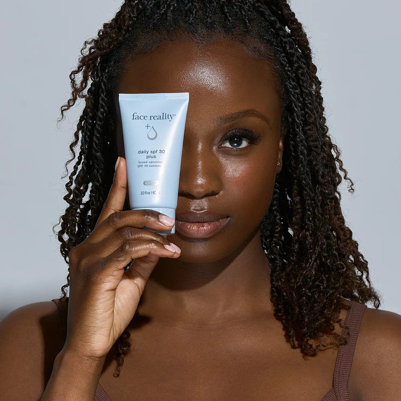 Woman holding a 'face reality' skincare product