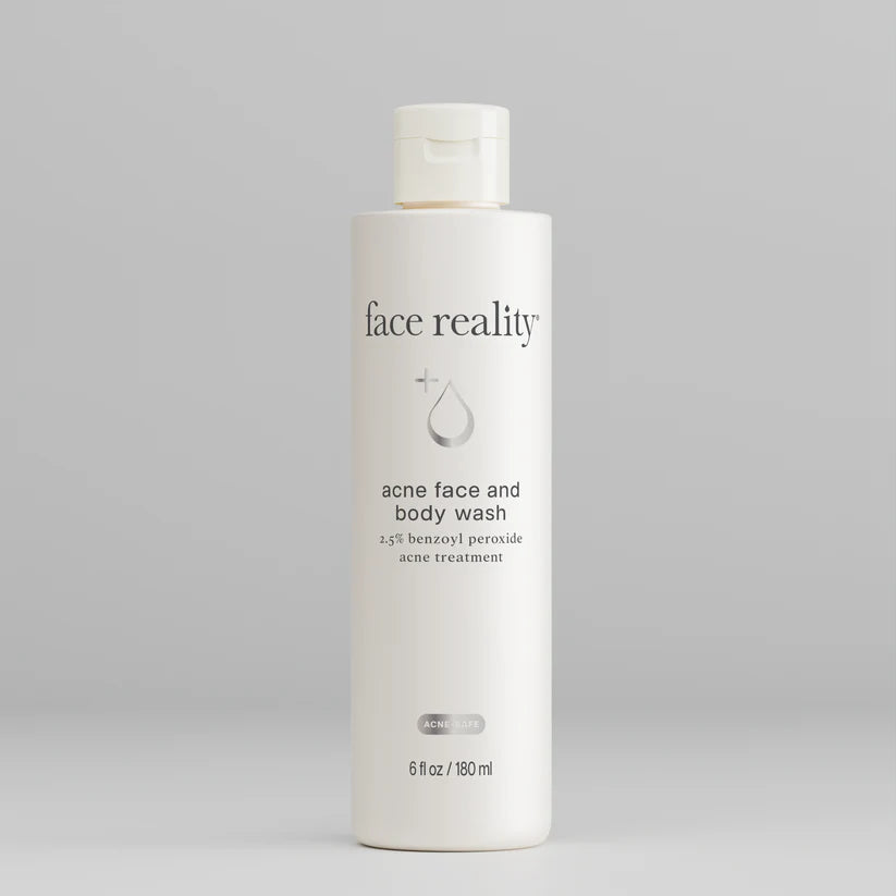 White bottle of 'face reality' acne face and body wash on a gray background
