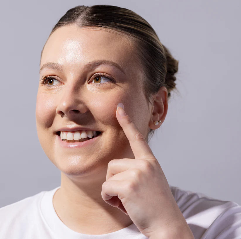 Woman applying an InvisiClear hydrocolloid pimple patch