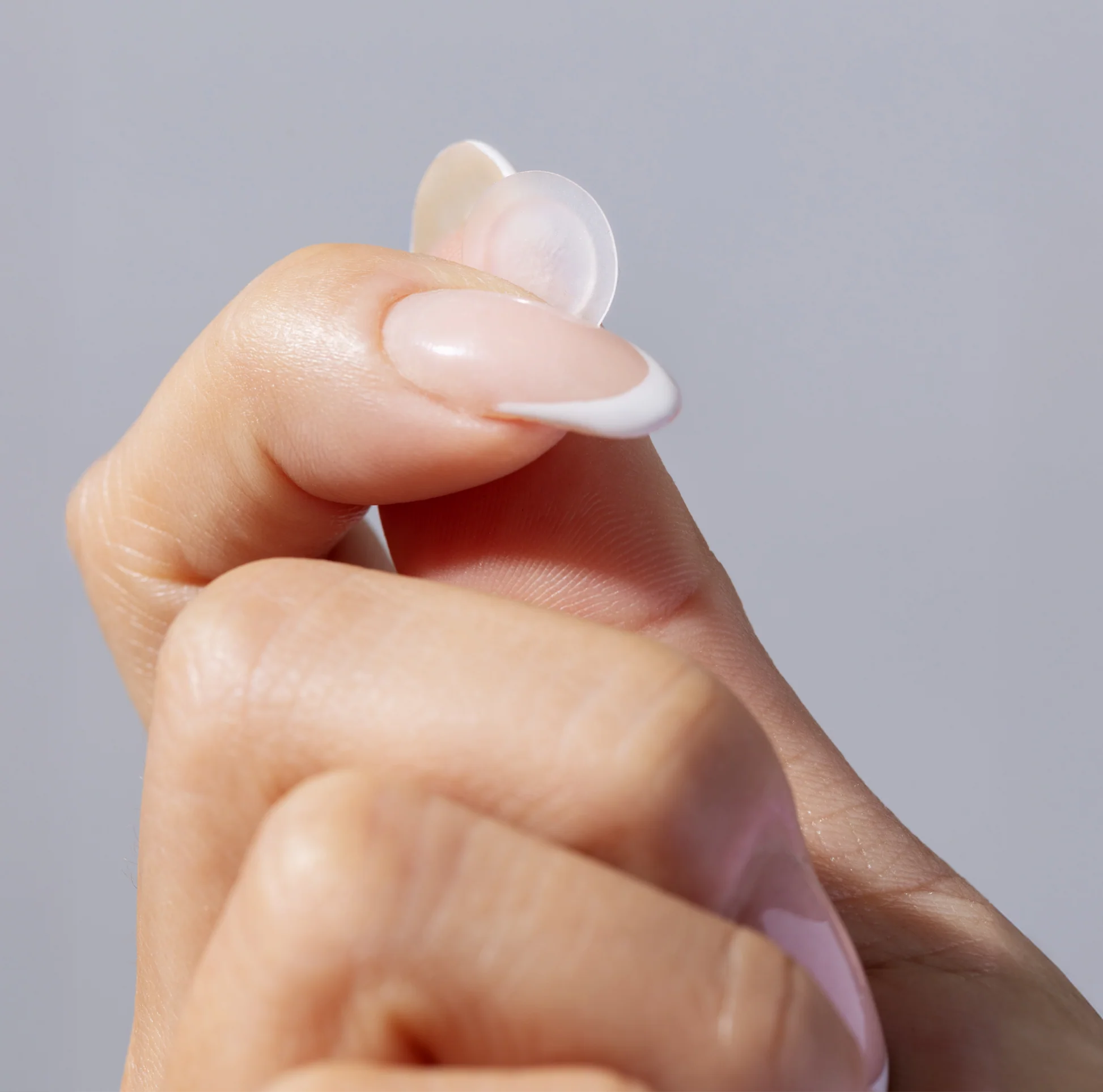 Hand holding an InvisiClear Pimple Patch